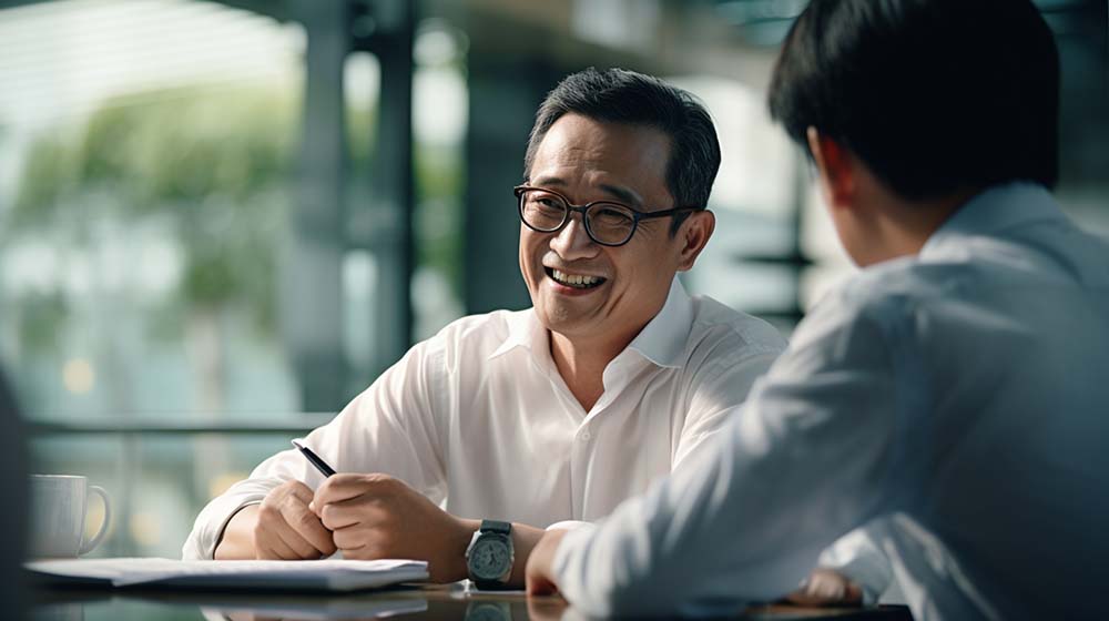 A fund manager smiling and having a conversation with his client